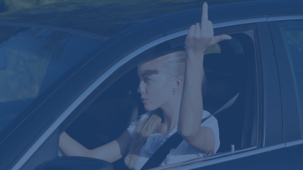 Vrouw in auto steekt middelvinger op naar de politie - advocaat nodig wegens beschuldiging van belediging?